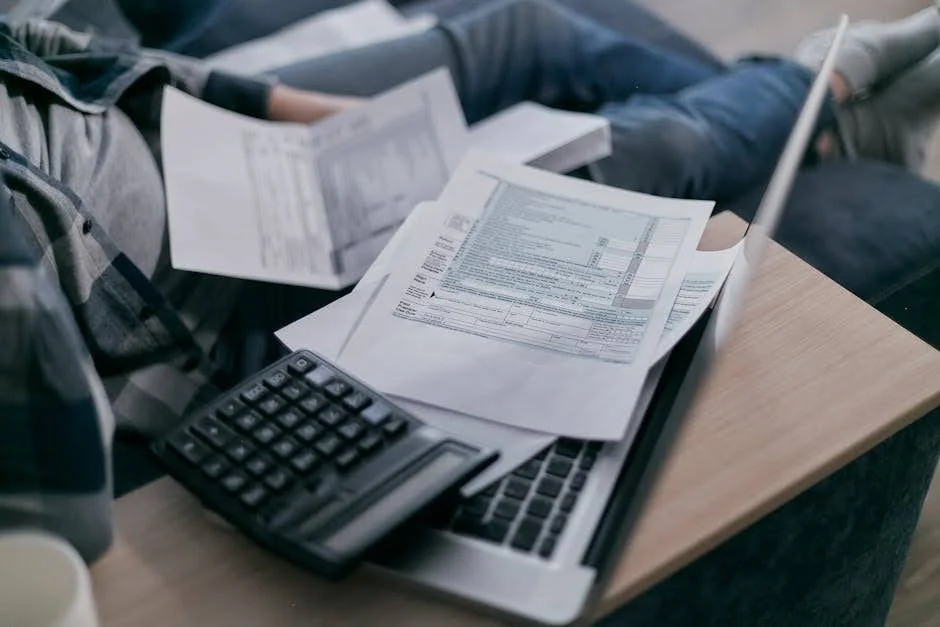 Factures, calculatrice et ordinateur portable réunis sur un bureau